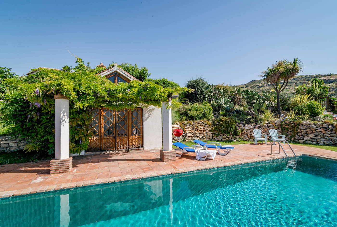 Zona de piscina rodeado de hermosos jardines