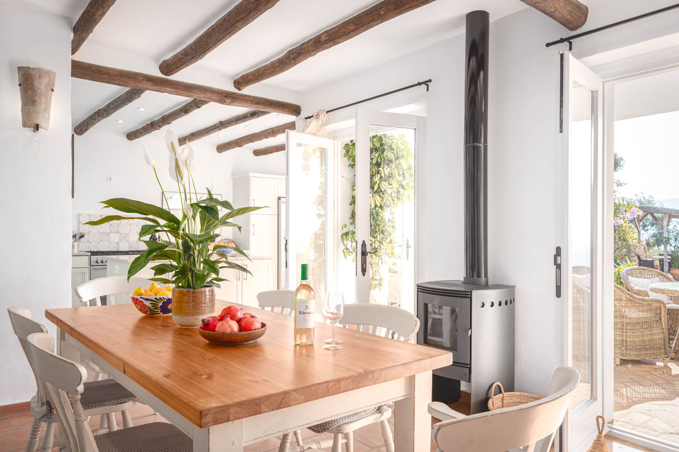 Comedor con cocina y puertas que abren a terraza