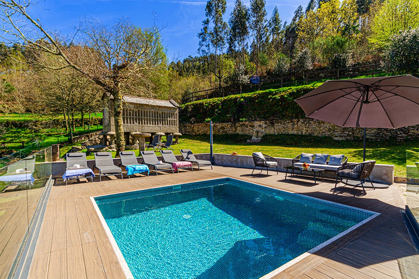 Casa con piscina rodeada de arboleda y jardines
