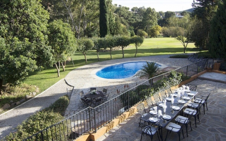Mesa para 10 personas sobre el jardín de la piscina