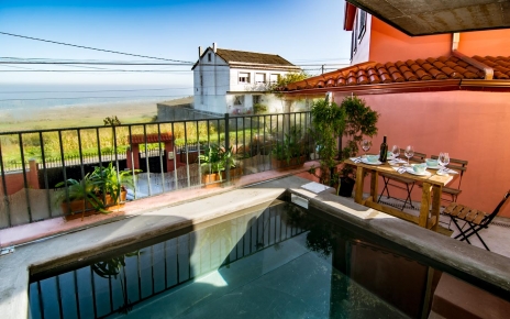 Sentado junto a la pequeña piscina con vistas al mar