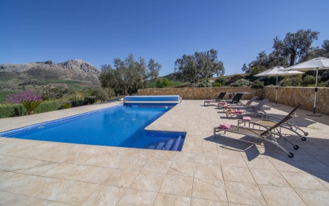 Zona de piscina con mesa de ping-pong, sombrillas y tumbonas