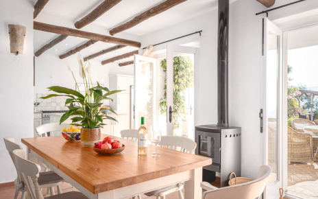 Comedor con cocina y puertas que abren a terraza