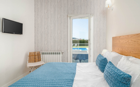 Habitación con ventana que mira a zona de piscina